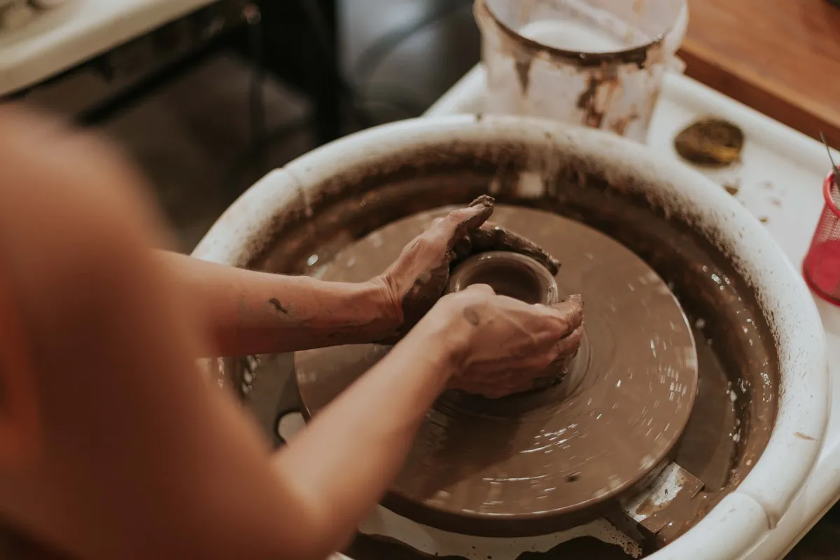 Ceramicist shaping clay in a warm Pembrokeshire studio